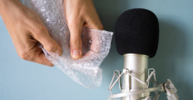 vrouw kraakt bubbeltjesfolie voor een microfoon en maakt een asmr-video