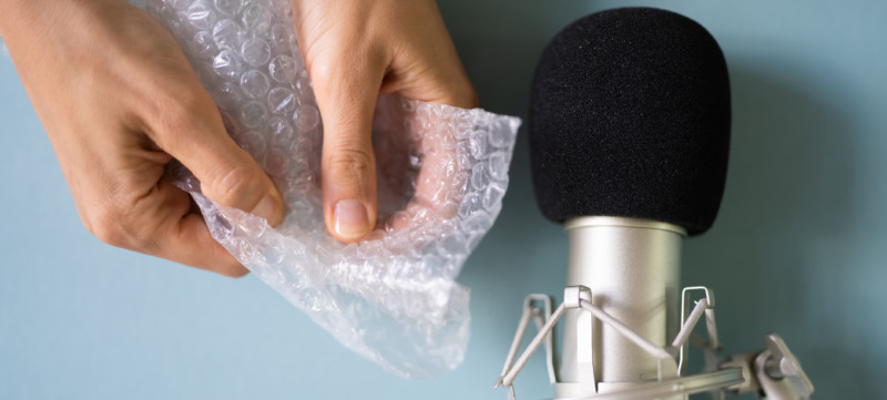 vrouw kraakt bubbeltjesfolie voor een microfoon en maakt een asmr-video