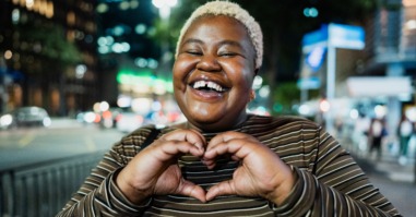 vrouw doet een hartgebaar met haar handen als teken van dankbaarheid