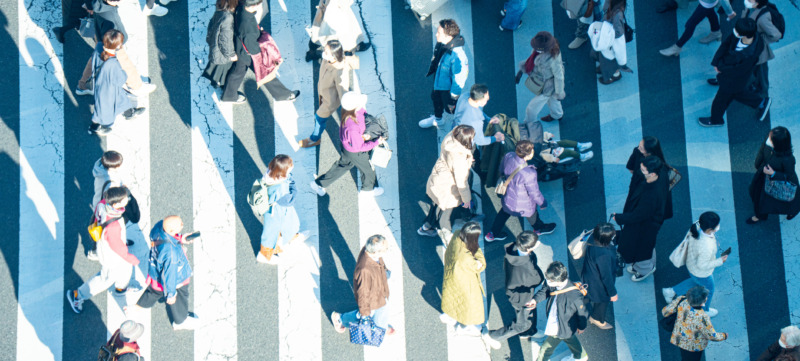 mensen lopen haastig over een zebrapad