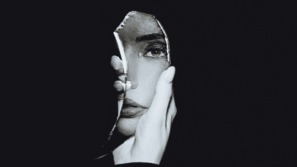 vrouw kijkt naar zichzelf in de spiegel