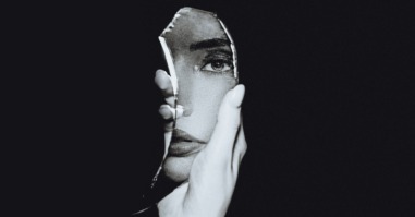 vrouw kijkt naar zichzelf in de spiegel