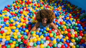 een man ligt in de ballenbak en streeft een rommelig en speels leven na