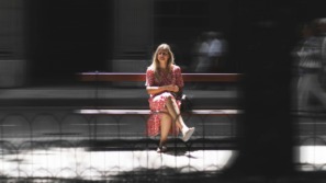 vrouw zit tevreden alleen op een bankje