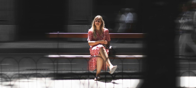 vrouw zit tevreden alleen op een bankje