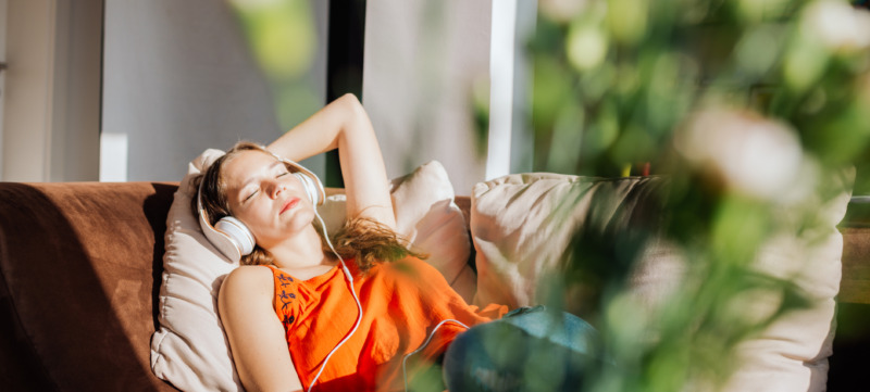 vrouw ligt prikkelvrij te relaxen met een koptelefoon op haar hoofd