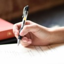 persoon schrijft met een pen haar gedachten op in een boekje