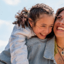 Dochter lachend op de rug bij haar moeder