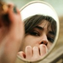 vrouw kijkt naar zichzelf in de spiegel