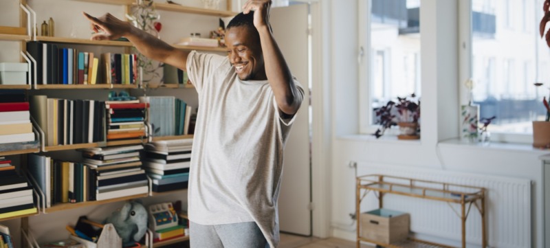 man heeft geen moeite met single zijn en danst alleen door zijn woonkamer