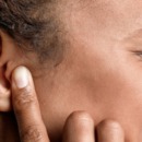 vrouw houdt handen over haar oren tegen de piep in haar oren