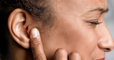 vrouw houdt handen over haar oren tegen de piep in haar oren