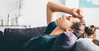 vrouw ligt verbitterd en gefrustreerd op de bank