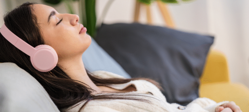 vrouw luistert ontspannen naar muziek met een koptelefoon