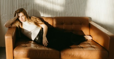 vrouw ligt lusteloos en moe op de bank