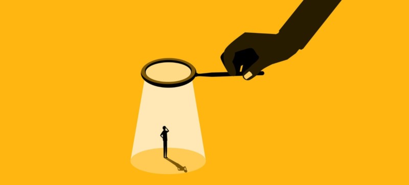 illustratie van een werknemer die met een vergrootglas in de gaten wordt gehouden