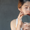 Vrouw kijkt in de spiegel met angst