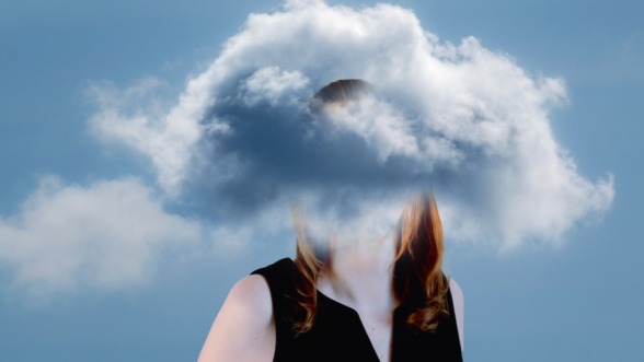 beeld van een vrouw die met haar hoofd in een wolk staat omdat haar brein overprikkeld is