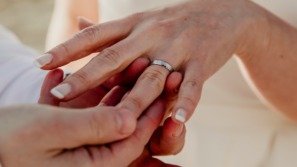 man doet trouwring om de vinger van partner