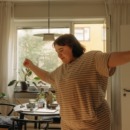 single vrouw danst vrolijk in de woonkamer