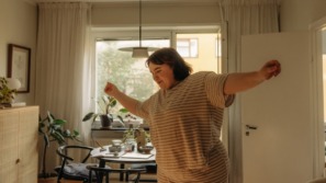 single vrouw danst vrolijk in de woonkamer