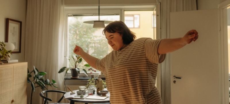 single vrouw danst vrolijk in de woonkamer