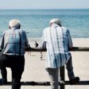 twee mannen staan met elkaar te praten en roddelen over andere mensen
