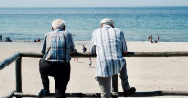 twee mannen staan met elkaar te praten en roddelen over andere mensen