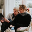 drie vrouwen zitten op een bank en vertellen elkaar over de familie door elkaar vragen te stellen