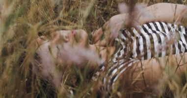 een vrouw ligt in het gras en maakt haar hoofd leeg