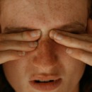 vrouw heeft last van migraine en grijpt naar haar hoofd