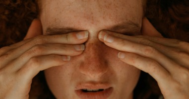 vrouw heeft last van migraine en grijpt naar haar hoofd