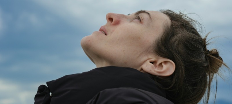 vrouw is overprikkeld en kijkt buiten naar de lucht om te ontspannen