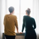 partners staan voor het raam en bespreken hun politieke voorkeur