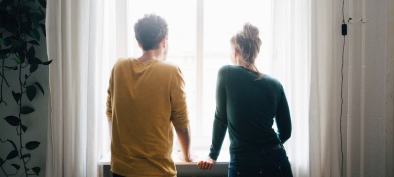 partners staan voor het raam en bespreken hun politieke voorkeur