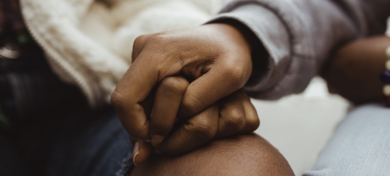 twee mensen houden elkaars handen vast om elkaar te helpen tijdens een verdrietige periode