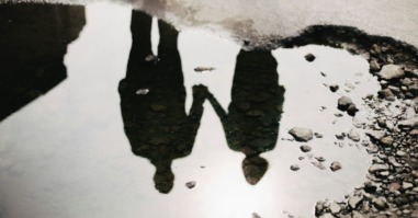 weerspiegeling in een plas van twee mensen in een relatie wat symbool staat voor een relatie die verwaterd