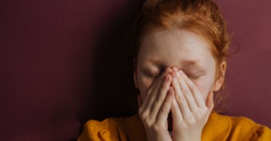 Vrouw met handen voor haar gezicht door angst