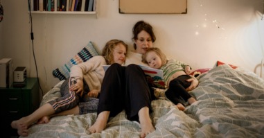 moeder leest haar kinderen voor uit een stripboek