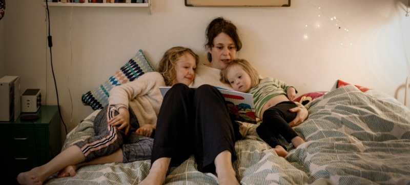 moeder leest haar kinderen voor uit een stripboek