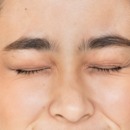 vrouw met ogen dicht omdat ze zich schaamt
