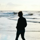 vrouw wandelt langs de nederlandse kust