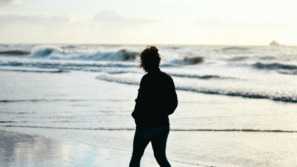 vrouw wandelt langs de nederlandse kust