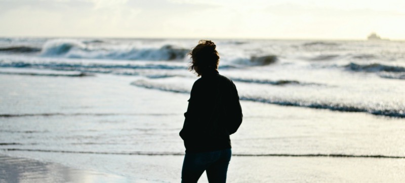 vrouw wandelt langs de nederlandse kust