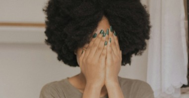 vrouw is verlegen en slaat haar handen voor haar hoofd