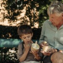 grootouder past op kleinkind en ze eten samen een ijsje