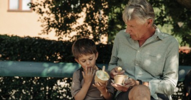 grootouder past op kleinkind en ze eten samen een ijsje