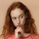 vrouw kijkt twijfelend weg omdat ze het imposter syndroom heeft