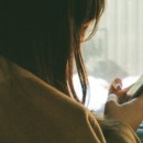 vrouw zit in haar telefoon gedoken en praat minder