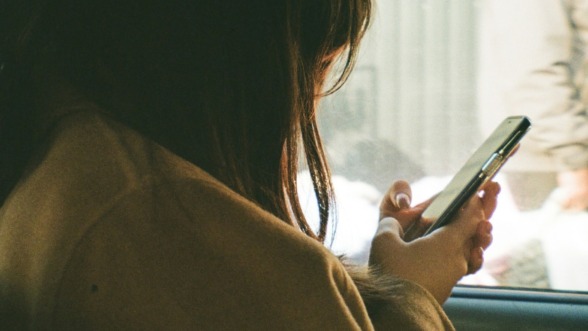 vrouw zit in haar telefoon gedoken en praat minder